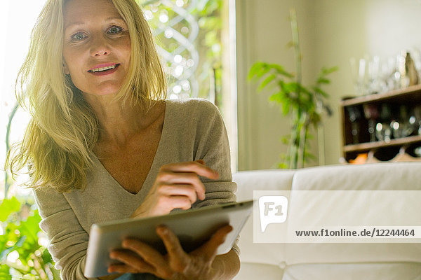 Mature woman using digital tablet at home