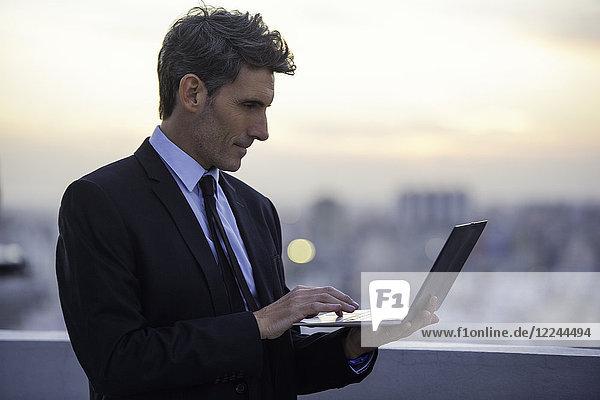 Geschäftsmann auf dem Dach mit Laptop