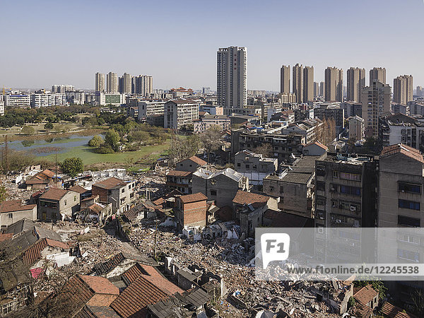 Tall buildings rise behind torn down old apartment buildings  Jingzhou  Hubei  China  Asia