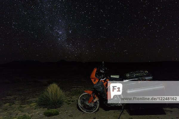 Schwer bepacktes Motorrad auf der Hochebene vor dem Sternenhimmel  Putre  Region de Arica y Parinacota  Chile  Südamerika