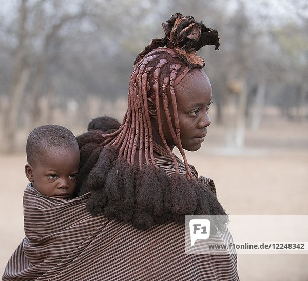 Junge  verheiratete Frau  die ein Baby in einem Tuch trägt  Porträt  Kaokoveld  Namibia  Afrika