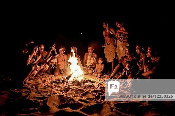 Buschleute der Ju/'Hoansi-San sitzen am Lagerfeuer Dorf //Xa/oba bei Tsumkwe Otjozondjupa Region Namibia Afrika