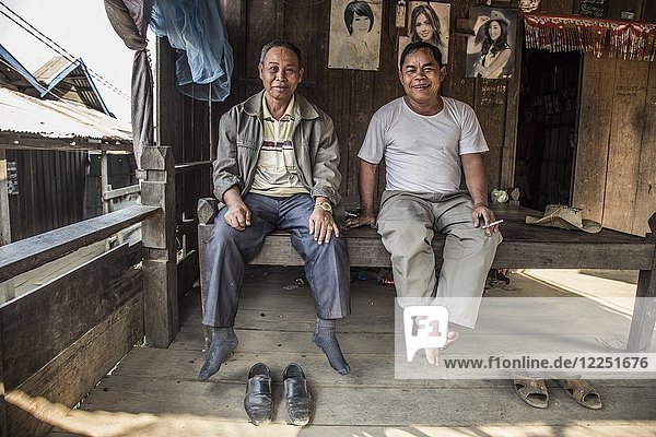 Zwei Einheimische sitzen in ihrer Hütte  Preah Meas  Sen Monorom  Mondulkiri  Kambodscha  Asien
