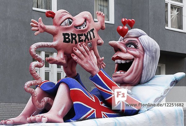 British Prime Minister Theresa May holds a deformed child  Brexit-Baby  political caricature to Brexit  motto caravan during Carnival Monday procession 2018  Düsseldorf  North Rhine-Westphalia  Germany  Europe