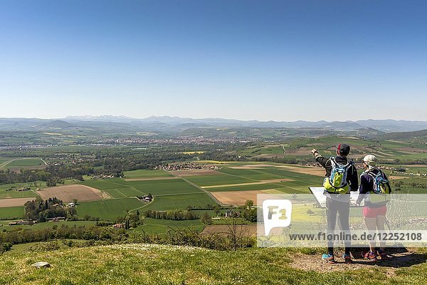 Hikers enjoying the view from Usson village on plain of Limagne and the volcanic landscape of the Chaine des Puys  Puy de Dome department  Auvergne  France  Europe