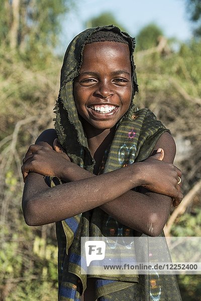 Junge  ca. 12 Jahre  posiert lächelnd mit verschränkten Armen  Hamer-Stamm  Turmi-Markt  Region der südlichen Nationalitäten und Völker  Äthiopien  Afrika