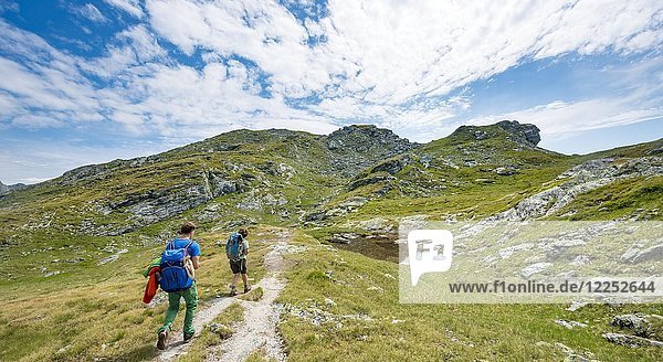 Two hikers at a small lake  Schladminger Höhenweg  Schladminger Tauern  Schladming  Styria  Austria  Europe