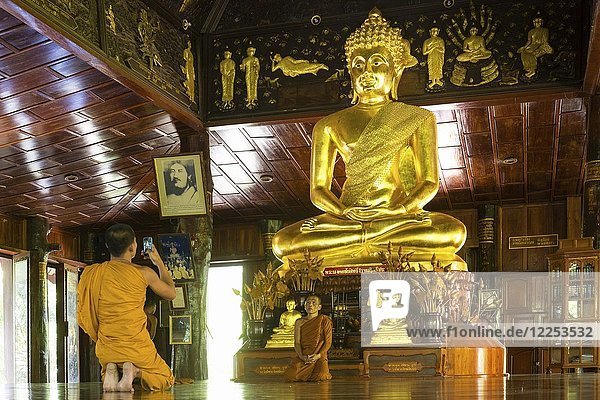 Mönche vor der goldenen Buddha-Statue  Wat Phuttha Nimit Phra Saiyat  Phra Buddha Phukhao  Bezirk Sahatsakhan  Kalasin  Isan  Thailand  Asien