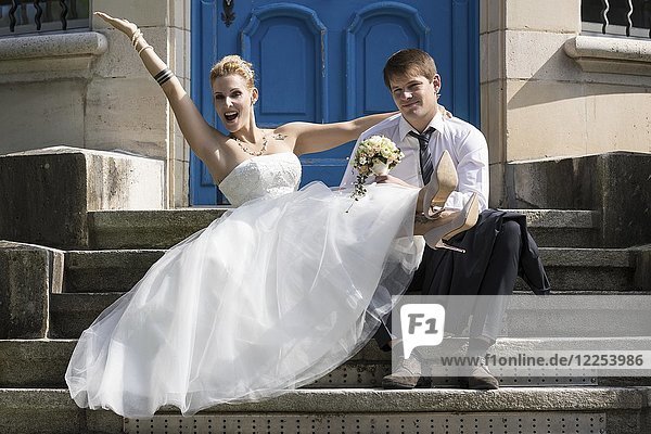 Junges Brautpaar sitzt auf einer Treppe und posiert glücklich  Schweiz  Europa