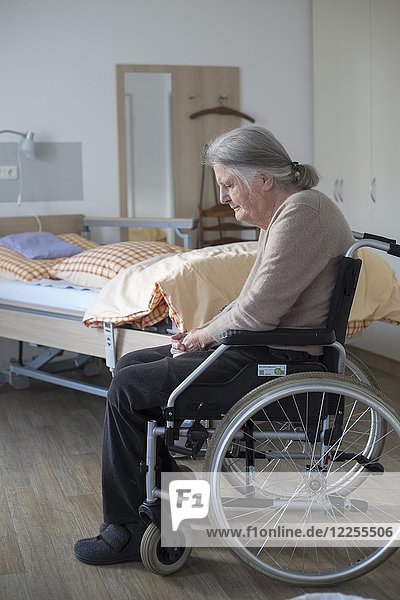 Demenzkranke Seniorin im Rollstuhl allein in ihrem Zimmer in einem Pflegeheim  Köln  Nordrhein-Westfalen  Deutschland  Europa