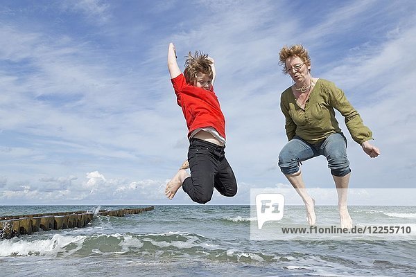 Mutter und Sohn springen am Strand  Ahrenshoop  Fischland  Mecklenburg Vorpommern  Deutschland  Europa