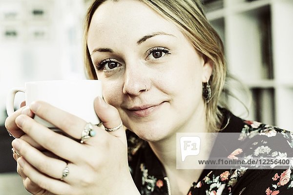 Young woman with a cup of coffee in her hand  portrait  Germany  Europe