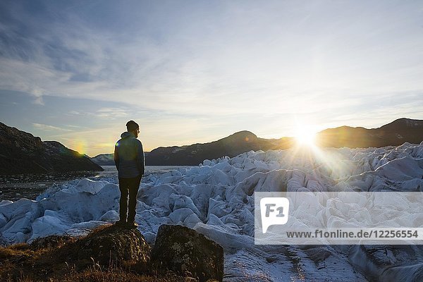 Man standing on furrowed glacier at sunset  West Greenland  Greenland  North America