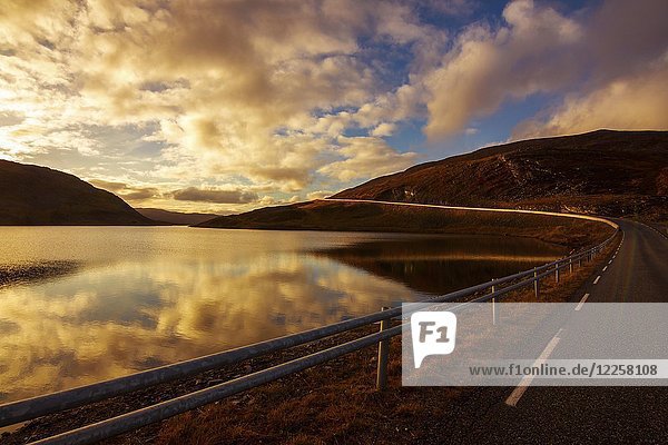 Sonnenuntergang mit verlassener Straße am Nordkap Finnmark Norwegen Europa