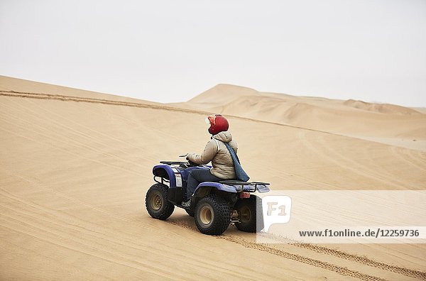 Frau fährt mit Quad über Sanddünen bei Swakopmund  Namibia  Afrika