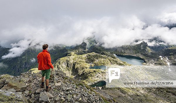 Hiker  Clouds over the ridge  view from Greifenberg to Klafferkessel  Oberer Klaffersee  Lungauer Klaffersee  Zwerfenbergsee  Schladminger Höhenweg  Schladminger Tauern  Styria  Austria  Europe