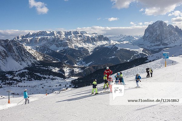 Children with ski instructor on the ski slope  Seceda ski area  in the back Sella massif  Sankt Cristina in Val Gardena  Dolomites  South Tyrol  Alto Adige  Italy  Europe