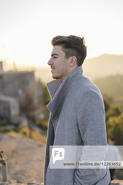 Fashionable young man wearing grey coat