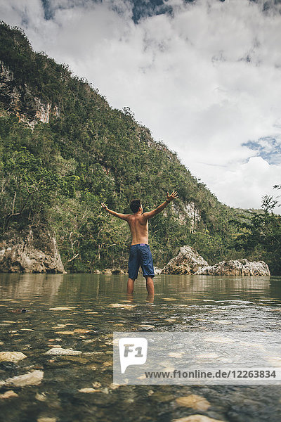 Cuba  Baracoa  Young man standing in Yumuri river  rear view