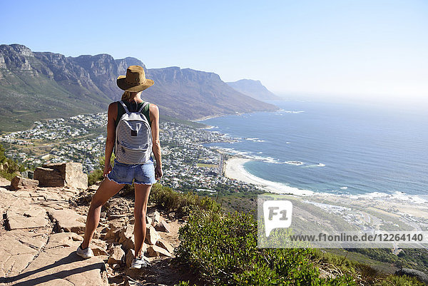 South Africa  Cape Town  woman standing looking at the coast during hiking trip to Lion's Head