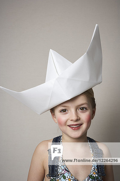 Porträt eines lächelnden kleinen Mädchens mit großem Papierboot