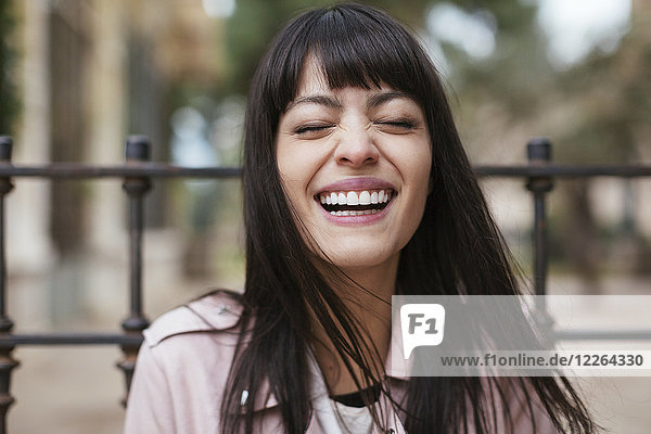 Porträt der lachenden jungen Frau im Freien