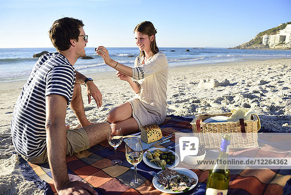 Happy couple having a picnic on the beach