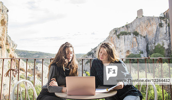 Spanien  Alquezar  zwei Frauen arbeiten zusammen mit Laptop auf der Terrasse