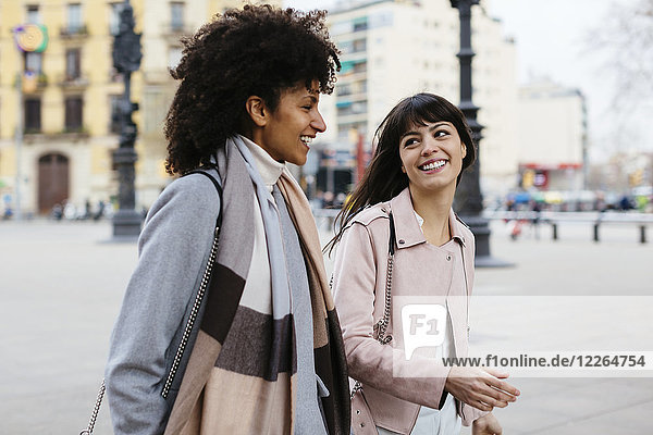 Spanien  Barcelona  zwei glückliche Frauen zu Fuß in der Stadt