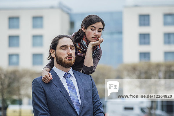 Portrait of displeased businessman and woman outside office building
