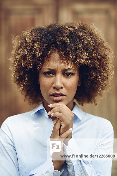 Porträt einer ernsthaften Frau mit Afro-Frisur im Freien