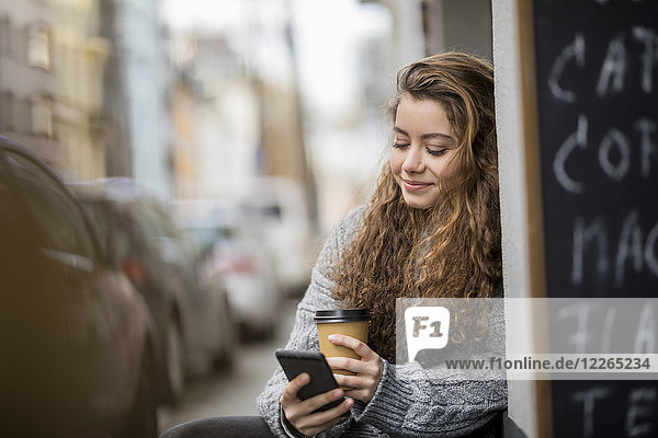 Teenagermädchen trinkt Kaffee  liest Textnachrichten