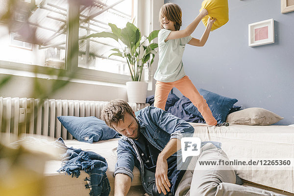 Father and son having a pillow fight at home