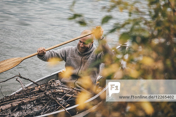 Kanada  British Columbia  Mann mit Holz im Kanu auf dem Boya Lake