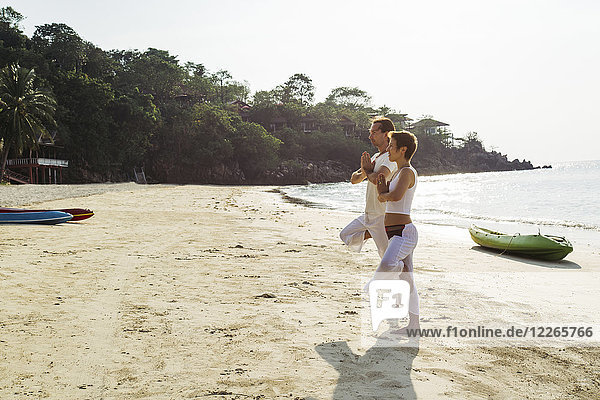 Thailand  Koh Phangan  couple doing yoga on a beach