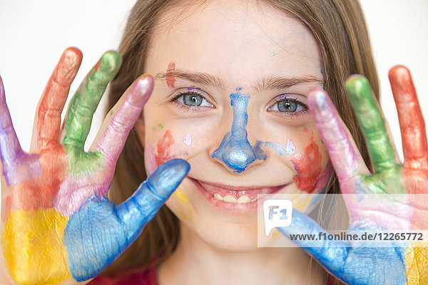 Porträt eines lächelnden Mädchens mit Fingerfarben auf den Händen