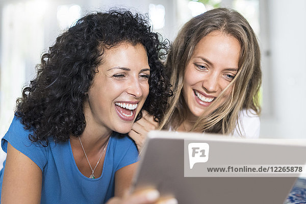 Two happy women looking at tablet