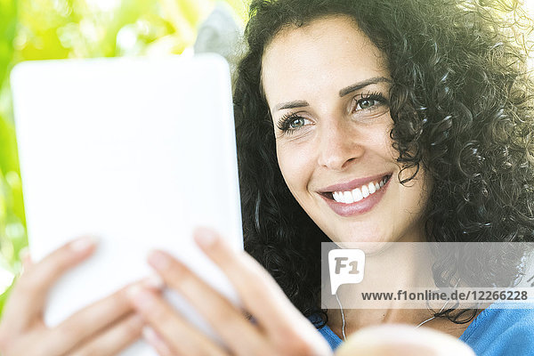 Portrait of smiling woman holding e-reader