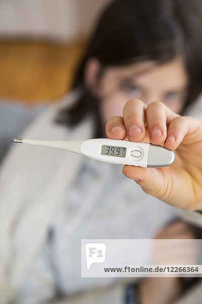 Girl's hand holding clinical thermometer  close-up