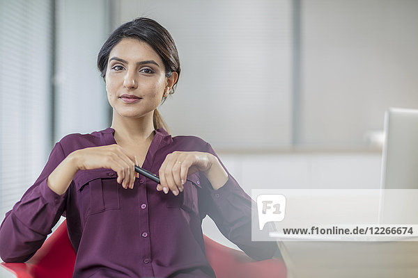 Porträt einer selbstbewussten Geschäftsfrau mit Laptop im Büro