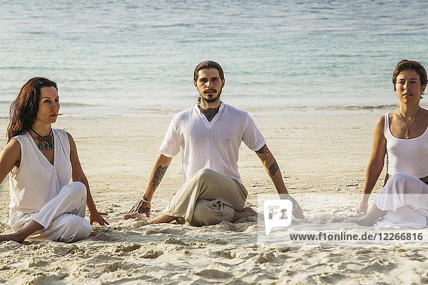 Thailand  Koh Phangan  drei Leute beim Yoga am Strand