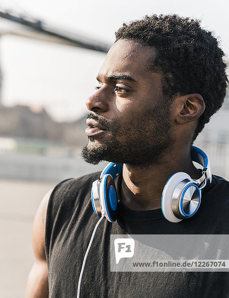 Portrait eines jungen Mannes mit Kopfhörer im Freien