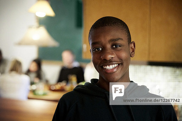 Porträt eines lächelnden Jungen  der zu Hause in der Küche steht.