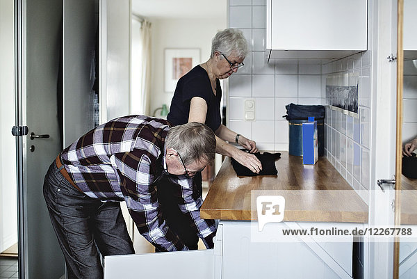 Seitenansicht des pensionierten Seniorenpaares bei der Arbeit im Bad zu Hause