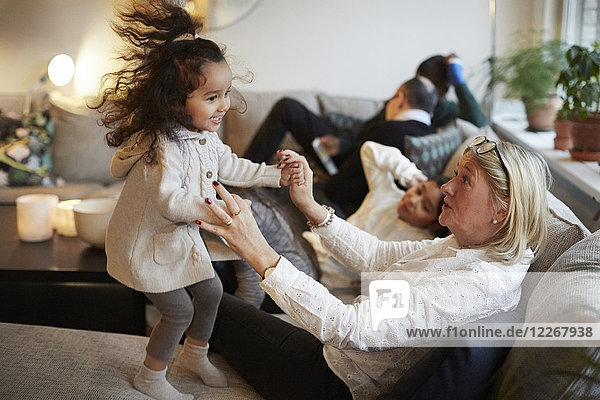 Mädchen spielt mit Großmutter auf dem Sofa von der Familie zu Hause