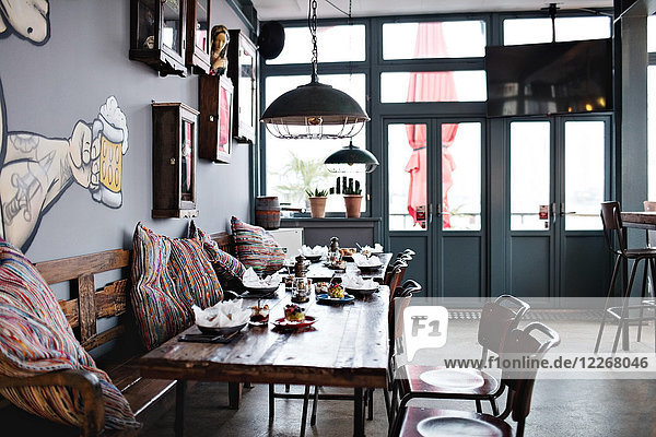 Dining table amidst bench and chairs at restaurant
