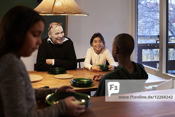 Fröhliches Familiengespräch am beleuchteten Tisch