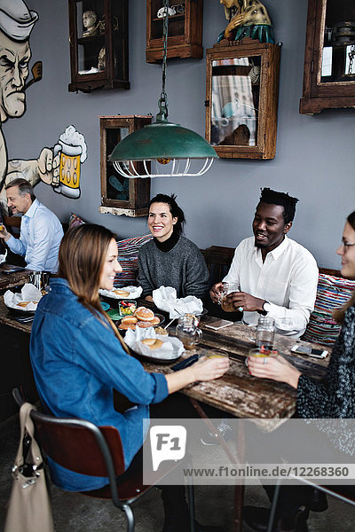 High angle view of multi-ethnic friends enjoying brunch at restaurant