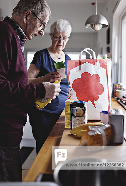 Seniorenpaar im Ruhestand mit Lebensmitteln auf der Küchenzeile zu Hause