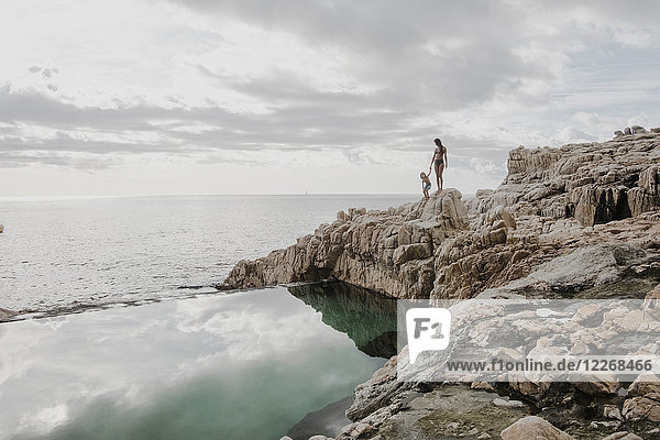 Mutter mit Sohn am Swimmingpool am felsigen Meeresufer  Costa Brava  Katalonien  Spanien